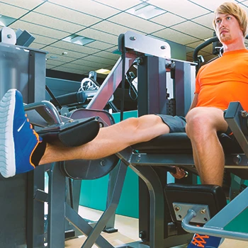 A person doing seated leg extensions at the gym