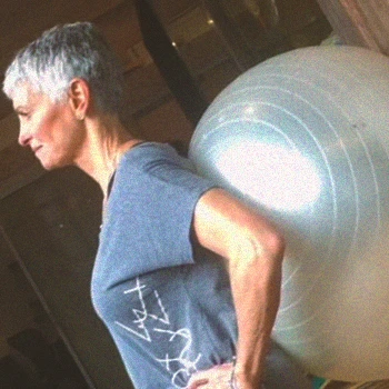 A person doing spanish squats at the gym with an exercise ball