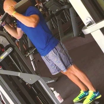 A person doing standing calf raises at the gym