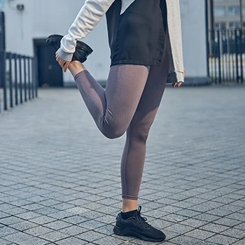 A woman doing a standing quad stretch