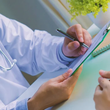 A doctor writing down on a clipboard