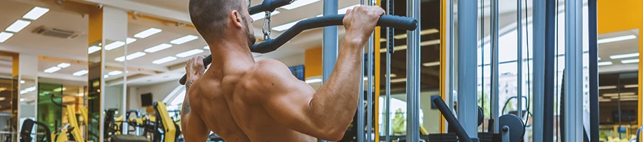 A person doing lat pulldowns on a machine at the gym