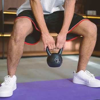 A person working out with a kettlebell at a home gym