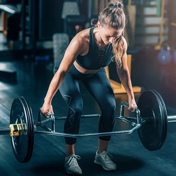 A woman doing trap bar deadlifts