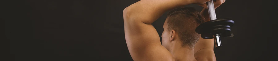 A person flexing his triceps in front of a black background