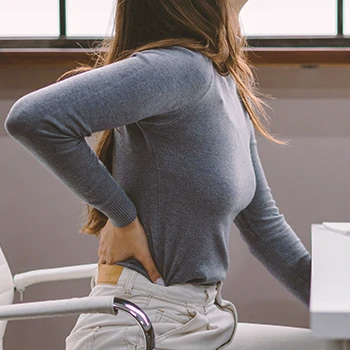 A person with lower back pain at an office