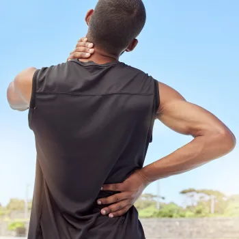 Man holding upper back and neck muscles