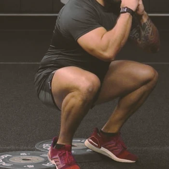 A person doing a heel elevated squat at the gym
