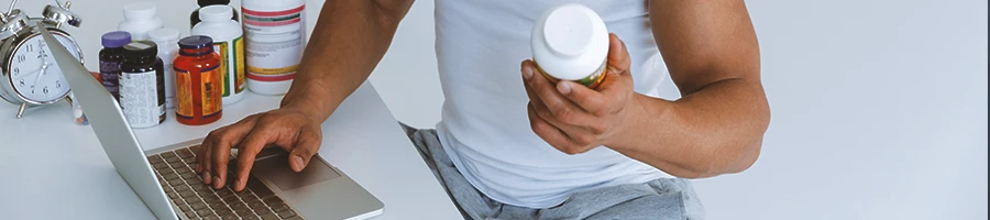 A buff male holding supplements