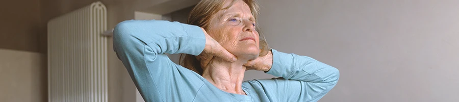 A senior doing neck stretches at home