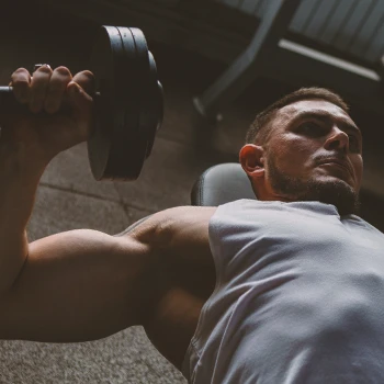 A person doing dumbbell bench press workouts