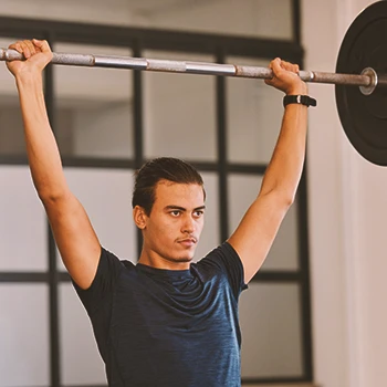 A person doing overhead press workouts at the gym