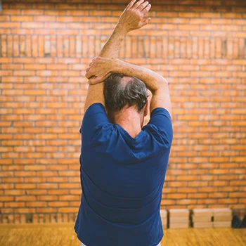 A senior doing shoulder stretch workouts