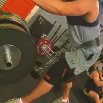 A person doing a Staggered Belt Squats