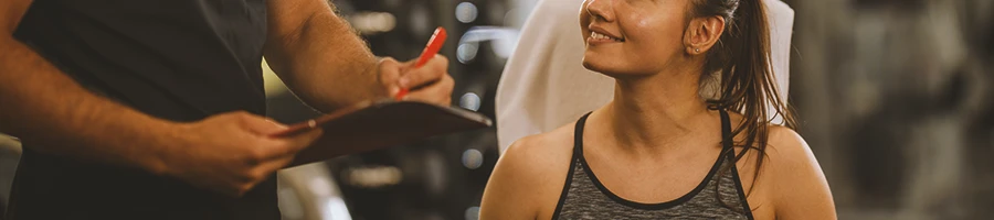 A gym coach teaching a person at the gym