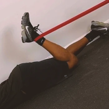 A person doing banded hamstring curls