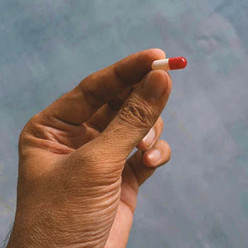 A person holding a Coenzyme Q10 pill