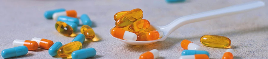 A bunch of supplements on a spoon on a white table