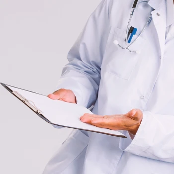 A doctor pointing to a clipboard