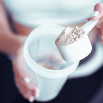 Woman holding a spoon of protein powder