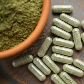Green pills and powder on table