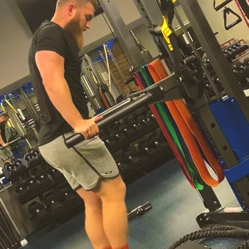 A person doing machine assisted dips at the gym