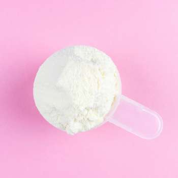 White protein powder on a pink background