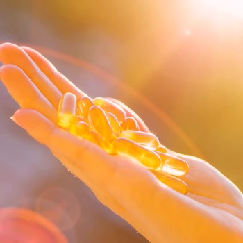 A person holding up vitamin D pills