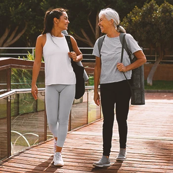 A senior and a young adult walking outside