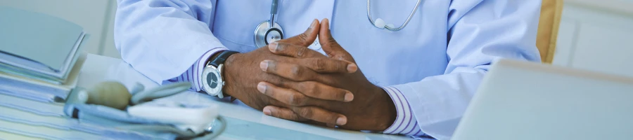 A doctor with hands together at a clinic
