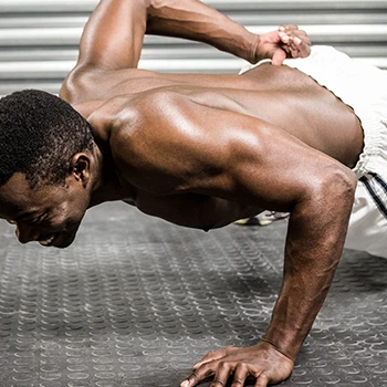 A shirtless man doing one hand push ups