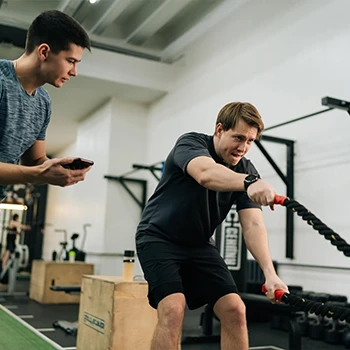 A man conditioning with ropes while there is a timer