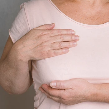 A woman holding her sagging breast