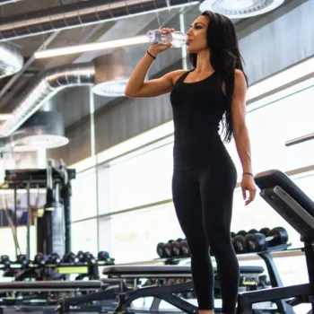 Ashley resting in the gym drinking water