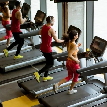 A man and woman running on a treadmill