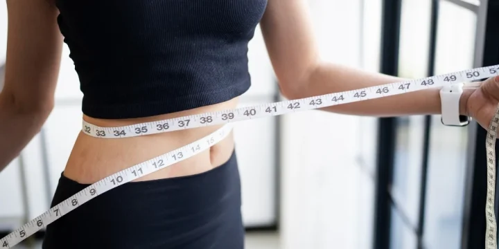 A woman measuring her waist