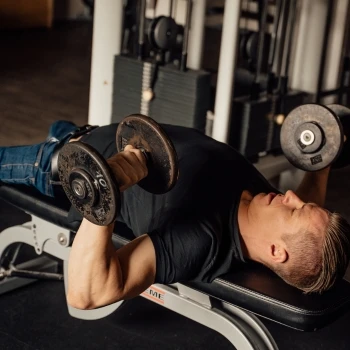 A man doing flat bench dumbbell press