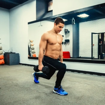 A man is doing reverse lunges with weights