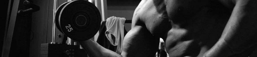 A man lifting a dumbbell showing his toned arms