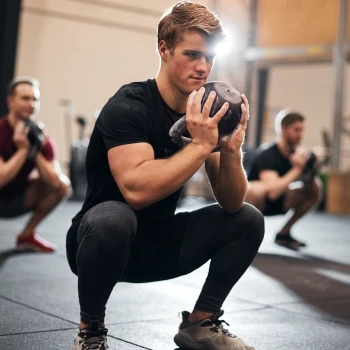 A man doing squats with weights