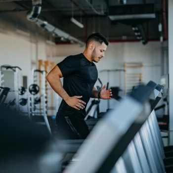 The man is running on a treadmill