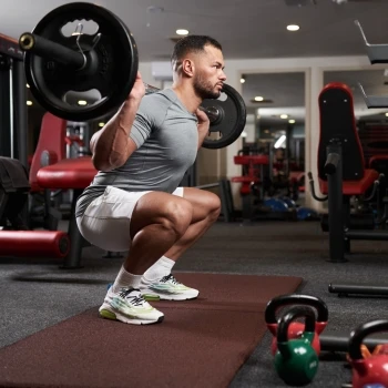 A man lifting weights and doing squats