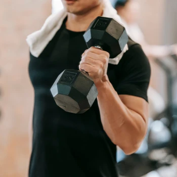 A guy working out using a dumbbell