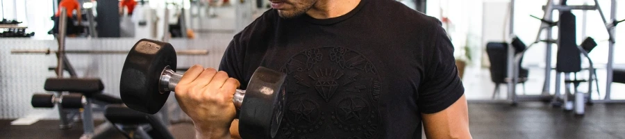 A guy doing bicep curls in the gym