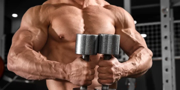 A muscular guy holding a dumbbell for his workout