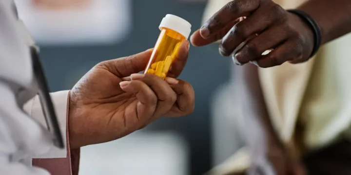 A man reaching out for testosterone pill from a doctor.