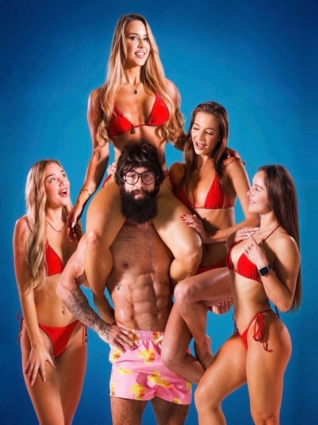 a muscular men surrounded by sexy girls in bikinis