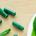 green supplements with a plate of green vegetables on top of kitchen counter